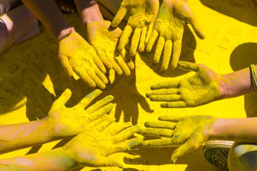 Des mains recouvertes de poudre jaune