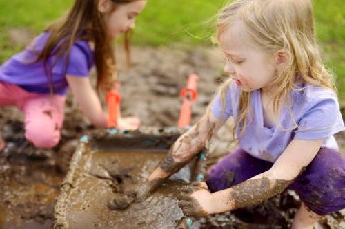 Meisjes spelen in de modder